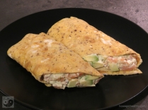 Frühstücksrolle mit Lachs-Avocado-Mayonnaise auf dem Teller